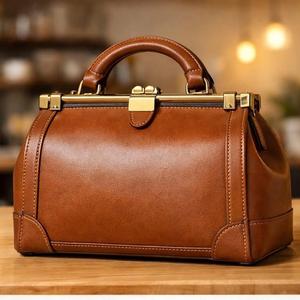 Este artículo es un bolso de mano con forma de baúl, hecho de cuero marrón, que recuerda a las maletas de viaje vintage. - Product Image 6