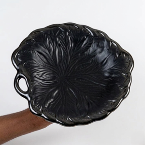 Plato de servir de cerámica negro hecho a mano con patrón de hojas en relieve, borde esculpido y asa lateral para una presentación elegante en la mesa. - Product Image 1