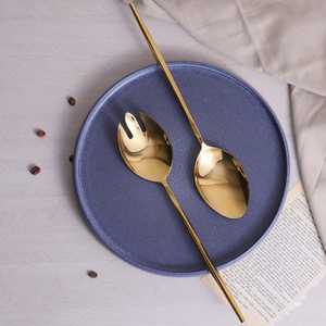 Cuillère de service contemporaine en métal avec finition dorée et manche noir pour une présentation élégante des aliments - Product Image 1