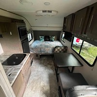 Caravane compacte avec lit, cuisine, coin repas et climatiseur, idéale pour le camping et les voyages en voiture