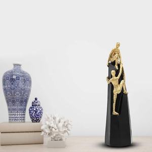 Statue moderne d'hommes grimpeurs en or et noir, symbole artistique de soutien, de leadership et de motivation - Product Image 1