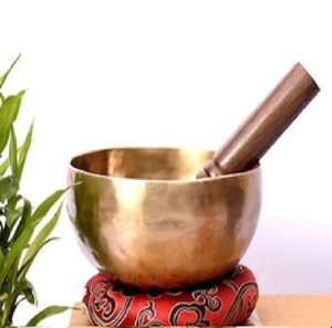 Cuenco tibetano clásico de latón dorado martillado a mano con percusor de madera sobre una base de seda roja. Disponible a precios de mayorista. - Product Image 1