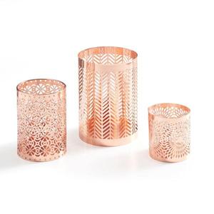 Los intrincados diseños recortados en un portavelas de metal crean sombras fascinantes que dansean con gracia por las paredes. - Product Image 5