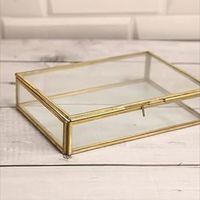 Boîte à bijoux rectangulaire en verre avec cadre doré et détail de chaîne