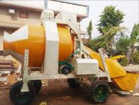 Bétonnière réversible jaune avec réservoir d'eau et trémie pour usage en construction