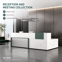 Bureau de réception moderne en L en bois avec surface aspect marbre blanc, accent vert et façade grise côtelée pour projets de hall d'entrée