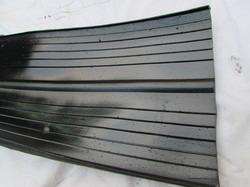 ชิ้นส่วนโลหะโค้งมนที่ขึ้นรูปด้วยเครื่องจักร วางอยู่บนโต๊ะในโรงงาน พร้อมฉากหลังที่มีชั้นวางเครื่องมืออุตสาหกรรมและอุปกรณ์ต่างๆ - Product Image 2