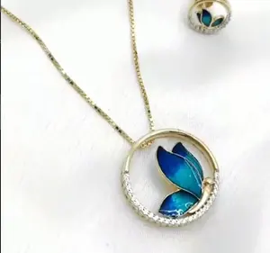 Joyería en tono dorado, regalo inspirado en la naturaleza para mujeres. Elegante conjunto de collar con colgante de mariposa azul y aretes. - Product Image 3