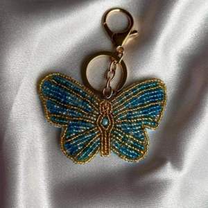 Breloque de sac en perles de verre, porte-clés insecte avec crochet en métal doré, pendentif clé à aile brodée, porte-clés papillon fait main en perles bleues - Product Image 1