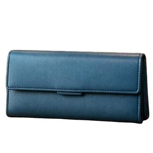 Ce produit est un portefeuille à rabat en cuir bleu marine pour femme, de style similaire aux sacs produits par cette marque. - Product Image 1