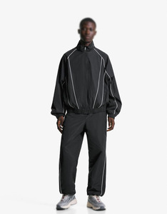 Ensemble de survêtement unisexe coupe-vent réfléchissant avec passepoil, veste et pantalon légers en polyester à fermeture éclair, vente en gros OEM - Product Image 1