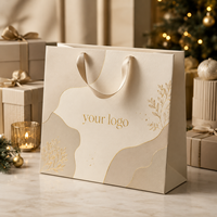 Maßgefertigte Creme-Matte Papiertüte mit Goldblatt-Verzierung Champagner-Satinband-Griffe Weihnachtsgeschenktüte OEM ODM FSC