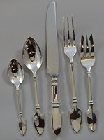 Ensemble de couverts modernes en acier inoxydable à manches coniques minimalistes, avec une surface polie miroir élégante, conçu pour un style contemporain.