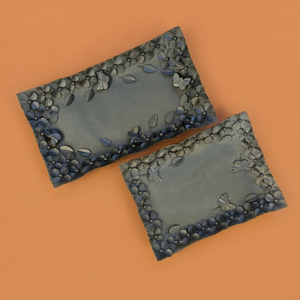 Cet ensemble de deux plateaux rectangulaires en métal présente des bordures à motifs floraux détaillés et des accents de papillons pour servir des aliments et décorer. - Product Image 1