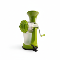 Presse-agrumes manuel à manivelle, en plastique vert, avec récipient de collecte, pour la préparation des aliments en cuisine.