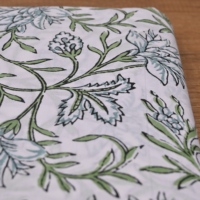 Tissu en coton imprimé à la main, motif floral blanc et vert traditionnel, design feuilles et vigne, idéal pour la confection de vêtements et la décoration.