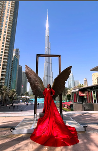Elegante sesión de fotos con vestido rojo en Dubái, con icónicas alas escultóricas y una vista majestuosa del Burj Khalifa en el fondo - Product Image 3