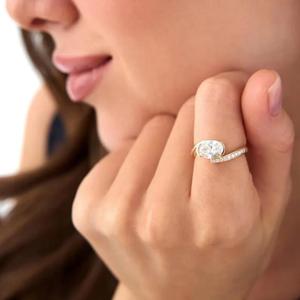 Anillo de compromiso de diamante blanco de corte ovalado en oro amarillo macizo con banda de diamantes pavé en medio de la banda y bisel asimétrico moderno. - Product Image 1