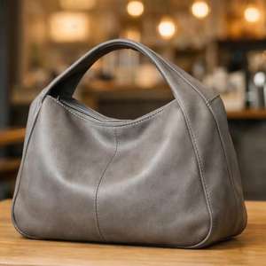 Bolso de mano negro estructurado con asa superior, diseñado como un accesorio versátil, adecuado para bolsos de cuero. - Product Image 5