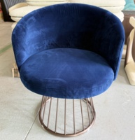 Fauteuil lounge en velours bleu foncé, dossier bas incurvé, base en fil métallique, design moderne pour hall d'hôtel, salon, bar, restaurant