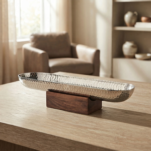 Elegante tazón plateado con diseño de martillado metálico sobre una base de madera elegante, perfecto para decoración de mesa moderna y para servir alimentos. - Product Image 1