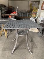 Table basse traditionnelle en fer avec plateau en treillis et base décorative, coussins imperméables pour usage en extérieur