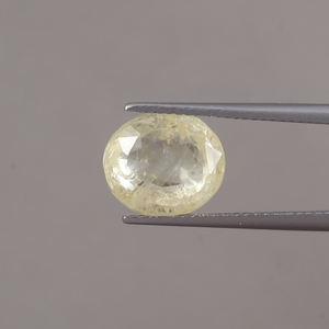 พลอยแซฟไฟร์สีเหลืองทรงรี ขนาด 11x9.5 มม. น้ำหนัก 6.58 กะรัต รับรองโดย IGI รูปทรงวงรี เปลี่ยนสีได้ด้วยการเคลือบแว็กซ์/น้ำมัน 100% จากธรรมชาติ - Product Image 1