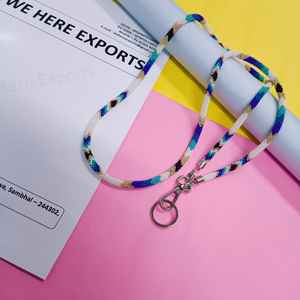 สร้อยประดับร่างกายทำมือหลากสีสันที่สวมใส่โดยผู้หญิงที่สวมเสื้อสีขาวและมีบัตรประจำตัวที่มองเห็นได้ แสดงถึงงานฝีมือของช่างฝีมืออย่างภาคภูมิใจ - Product Image 5