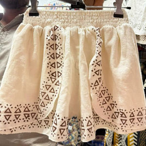 Shorts en coton blanc taille haute pour femme, style bohème chic, avec broderie géométrique tribale triangulaire et silhouette superposée à volants - Product Image 1