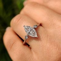 Magnifique bague de fiançailles à trois pierres de forme marquise avec une tige à bord coupé et des griffes de fixation sûres