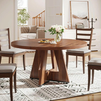 Table à manger ronde moderne en bois, finition noyer, base croisée de style mid-century