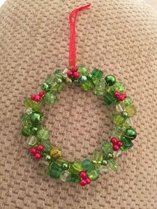 Adorno navideño artesanal con cuentas de cristal verde brillante y pequeños racimos de bayas rojas. - Product Image 2