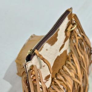 Bolso bandolera bohemio de cuero genuino con parche de piel de vaca y flecos largos para uso diario. - Product Image 3