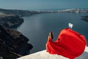 Impresionante sesión de fotos en Santorini con una elegante mujer en un vestido rojo vibrante sin espalda y con una cola larga y fluida. - Product Image 2