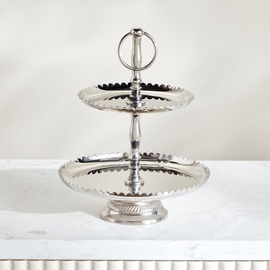 Magnifique support à gâteau à deux niveaux en argent, avec des plateaux à bords festonnés et un tige centrale en métal ornée d'un anneau rond. - Product Image 1
