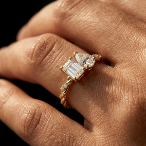 Bague de fiançailles en or jaune 18 carats avec deux pierres, taille émeraude et taille poire, motif Toi et Moi, avec accent de diamants sur l'alliance torsadée - Product Image 2