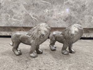 Majestic Metal Lion Statues (Set of 2) manes and a robust, prowling posture, these silver-toned sculptures symbolize strength - Product Image 1