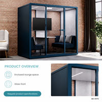 Pod lounge moderne bleu pour bureau, avec façade vitrée, sièges bleu marine, coussins gris clair et petite table