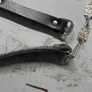 Ce produit est un accessoire vestimentaire des Highlands, décrit comme une chaîne sporran à motif celtique en nickel avec sangles en cuir noir. - Product Image 5