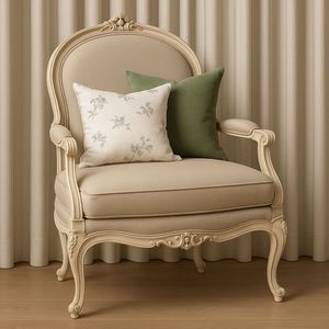 La chaise Antoinette Cashew Bergere présente un cadre en teck de style vintage de haute qualité et une revêtement en tissu texturé crème. - Product Image 2