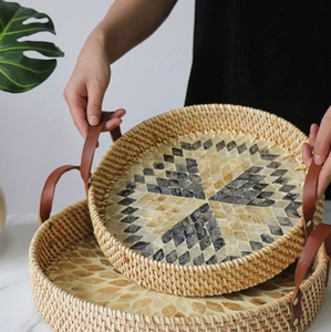 Juego de bandejas redondas de ratán tejido con base de incrustaciones de nácar natural y asas de cuero, disponible a precios de mayorista. - Product Image 1