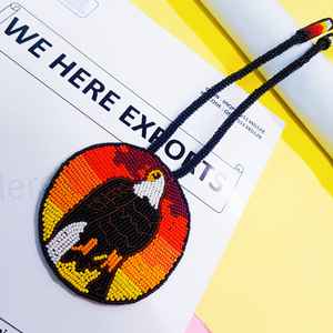 Collier pendentif aigle artisanal perlé avec perles noires, blanches, brunes, jaunes, oranges, rouges et cordon long pour un usage artistique et culturel - Product Image 1