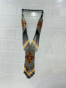 Collier artisanal en perles avec motifs tribaux géométriques, porté par une femme élégante, mettant en valeur la maîtrise artisanale traditionnelle. - Product Image 4