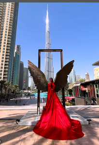 Elegante sesión de fotos con vestido rojo en Dubái, con icónicas alas escultóricas y una vista majestuosa del Burj Khalifa en el fondo - Product Image 4
