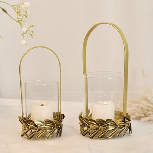 Ensemble de porte-bougies élégants en métal doré avec cylindres en acrylique et poignées cintrées pour une décoration intérieure chic et une ambiance lumineuse. - Product Image 4