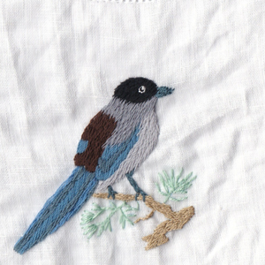 Serviette en lin avec motif d'oiseau bleu, les tons froids créent une ambiance sereine et raffinée à la table. - Product Image 3