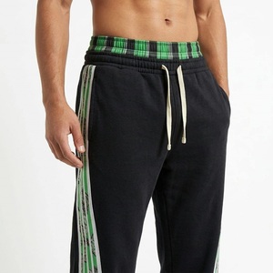 Pantalon de survêtement noir pour homme avec bandes latérales vertes, taille élastique et cordon de serrage, style décontracté, idéal pour l'automne - Product Image 2