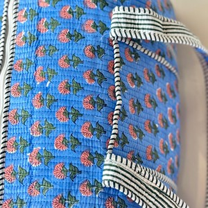 Sac de voyage matelassé bleu à motifs floraux avec poignées rayées, fermeture éclair, design portable pour un usage décontracté en voyage - Product Image 4