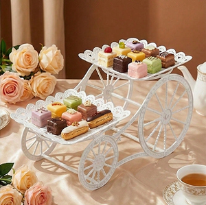 Carrito de metal blanco de diseño moderno, soporte para pasteles de dos niveles con ruedas decorativas, disponible a precios de mayorista. - Product Image 1