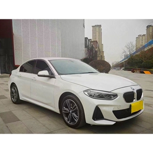 Vista frontal del sedán blanco BMW Serie 1 modelo 2023 en una escena de estacionamiento urbano - Product Image 3